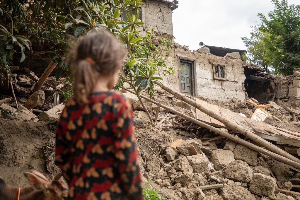 A six-year-old girl looks at the ruins of her home, destroyed in the 31 August earthquake in eastern Afghanistan.